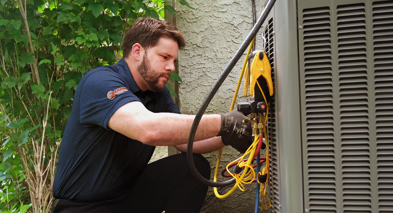 A professional Eanes HVAC technician inspecting an outdoor central air conditioning unit to provide residential AC repair and diagnostic services.
