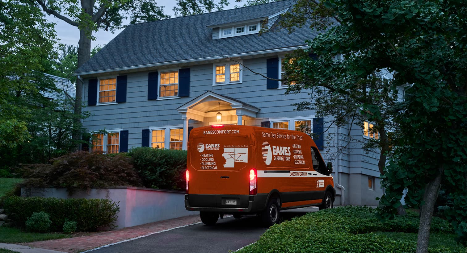 An Eanes service van parked in a residential driveway at night, arriving to provide 24/7 emergency heating repair services.