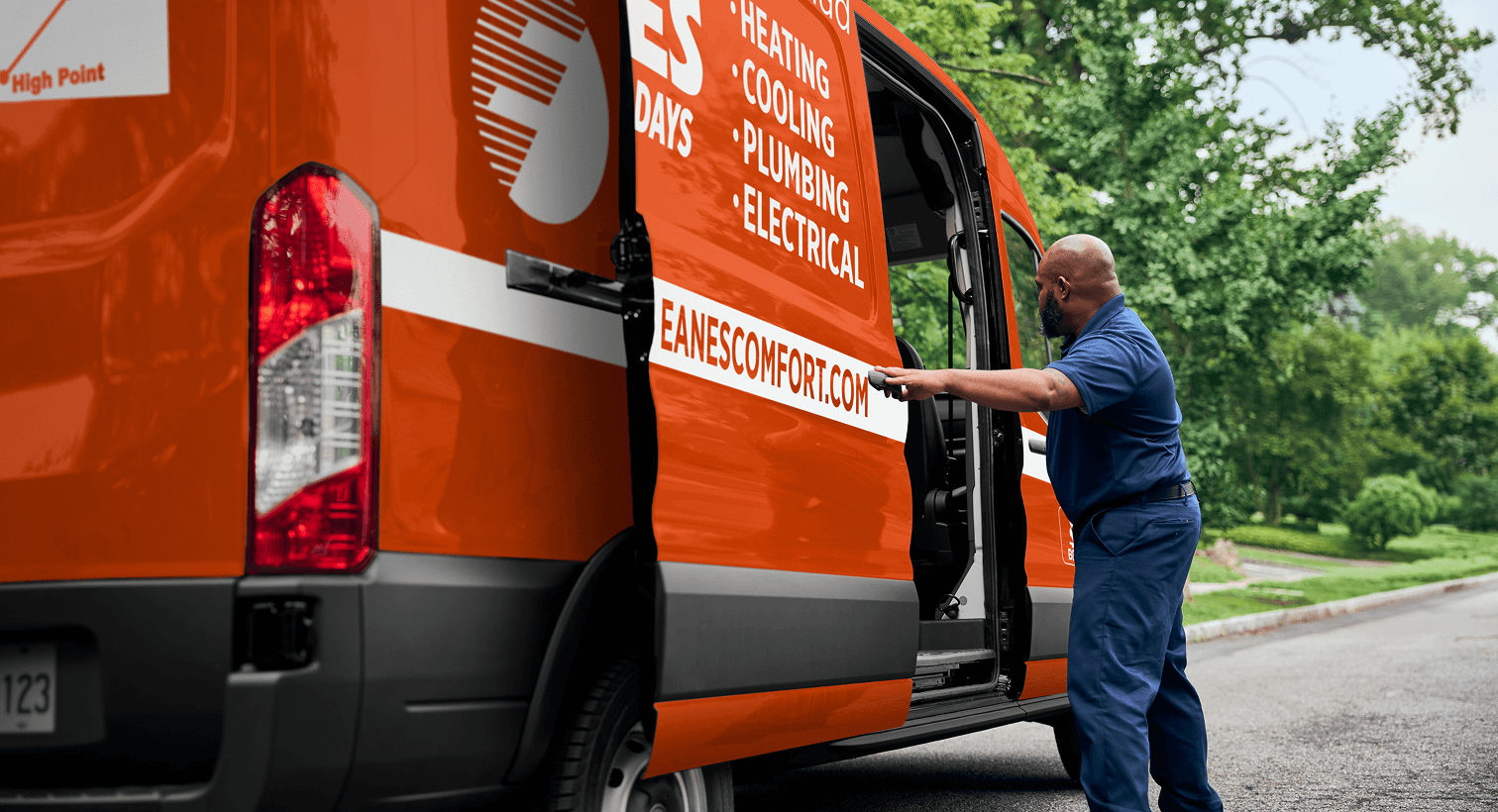 A professional Eanes technician opening a service van on a residential street, ready to provide home HVAC, plumbing, and electrical services.