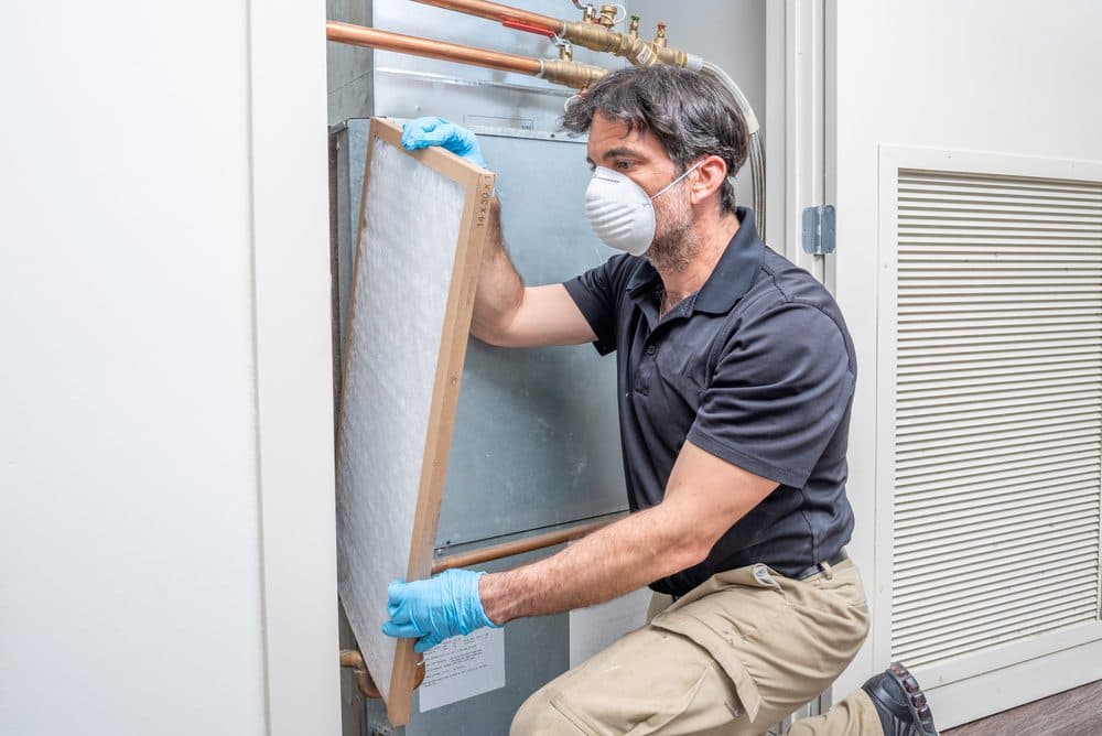 HVAC technician installing air filter